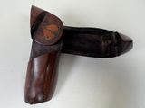 a wooden object with a wooden handle on a white surface