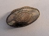 a silver plate with a picture of a coat of arms on it