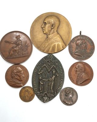 une image représentant un ensemble de pièces de monnaie et une médaille posées sur une surface blanche