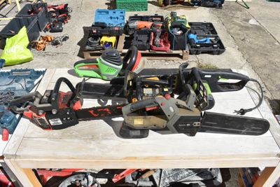 several chainsaws and other tools are on a table