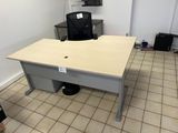 a desk with a chair and a monitor in a room