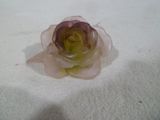 une petite fleur posée sur une surface blanche