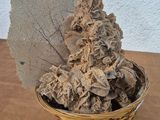 dried leaves in a basket on a table with a white wall in the background
