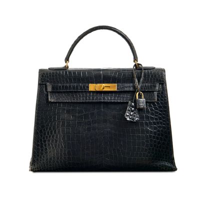 a black leather handbag with gold hardware on the handle