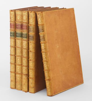 trois livres sont empilés sur une surface blanche