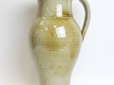 a green vase that is sitting on a white surface