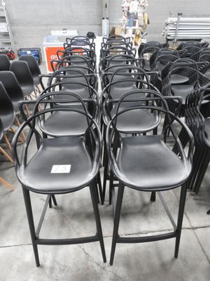 des rangées de chaises noires dans un entrepôt qui en regorge