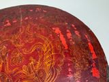 a red bowl with a design on it sitting on a table