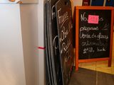 a blackboard sign on the wall next to a chalk board