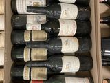 bottles of wine sit in a cardboard box on a table