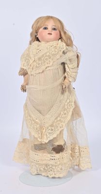 an old fashioned doll with a white dress and lace on it