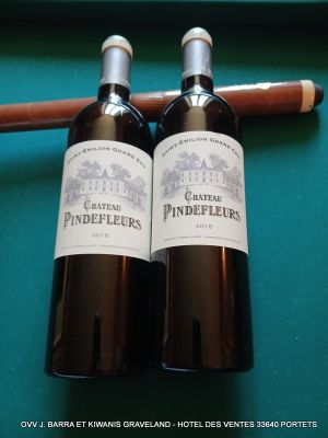 deux bouteilles de vin et un cigare posés sur une table de billard