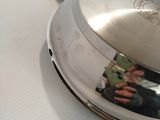 a silver pan on a white table with a red handle