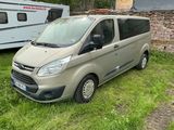 une camionnette argentée garée dans l'herbe à côté d'une remorque