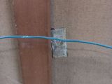 a blue wire that is connected to a wooden wall