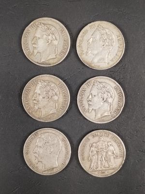 six pièces d'argent de tailles et de formes différentes sur une surface noire