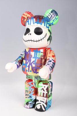 a multicolored teddy bear that is standing on a white surface