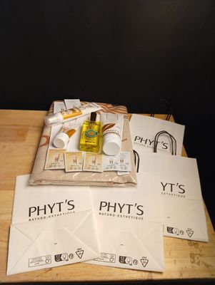une table en bois sur laquelle se trouvent une pile de livres et un flacon de parfum