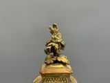 une horloge en or surmontée d'un oiseau