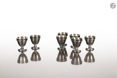 quatre tasses en argent posées les unes à côté des autres sur une table