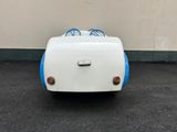 a small white and blue toy car parked in a parking lot