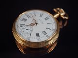 une montre de poche en or avec des chiffres romains
