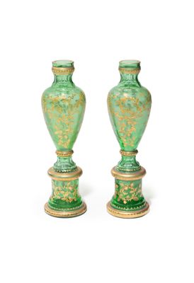pair of green vases with gold designs on them against a white background