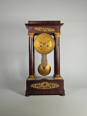 une horloge posée sur un support sur une table