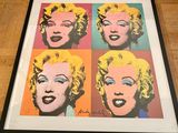 marilyn monroe pop art print in a black frame on a wooden floor
