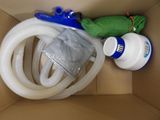 a box with a hose, a bottle of water, and a spray gun in it
