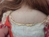 a close up of a doll ' s head with a red scarf around it