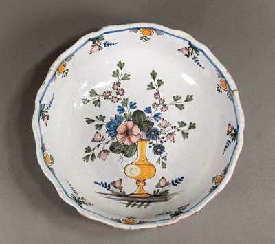 un petit bol sur lequel est posé un vase de fleurs