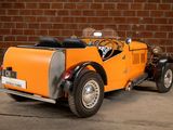 a small orange car parked in front of a brick wall