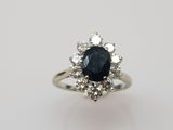 un gros plan d'une bague sertie d'un saphir bleu et de diamants blancs