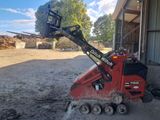 une petite machine rouge qui est posée dans la terre