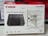 une boîte contenant des scanners Canon, faciles à utiliser et compacts, posée sur une table