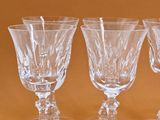 four clear wine glasses sitting on top of each other on a table