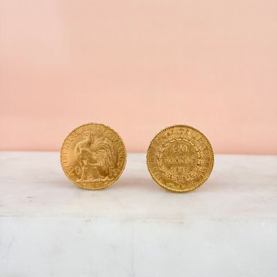 a pair of gold coins sitting on top of a marble counter