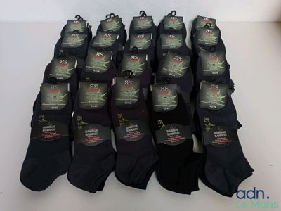 six paires de chaussettes noires pour homme posées sur une table blanche