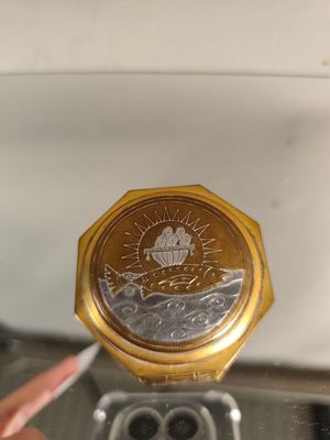 a gold coin with a picture of a boat on it