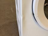 a white washing machine sitting on the floor in a room