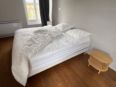 un lit blanc recouvert d'une couette blanche dans une chambre