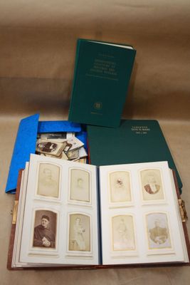 un livre ouvert posé sur une table, à côté d'une pile de photos