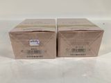two boxes of soap sitting on top of a white table