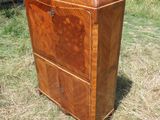 une vieille commode en bois posée dans un champ d'herbe