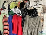 a lot of clothes hanging on a rack in a closet