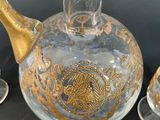 a glass pitcher with a gold decoration on it