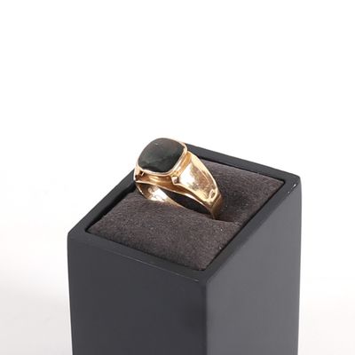 an image of a gold ring with a black stone in it