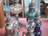 beaucoup de vieilles lampes posées sur une table recouverte d'une nappe rose