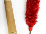 a roll of toilet paper and a red feather on a table